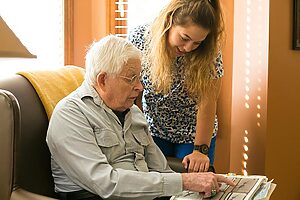Senior looking at a photo album with employee
