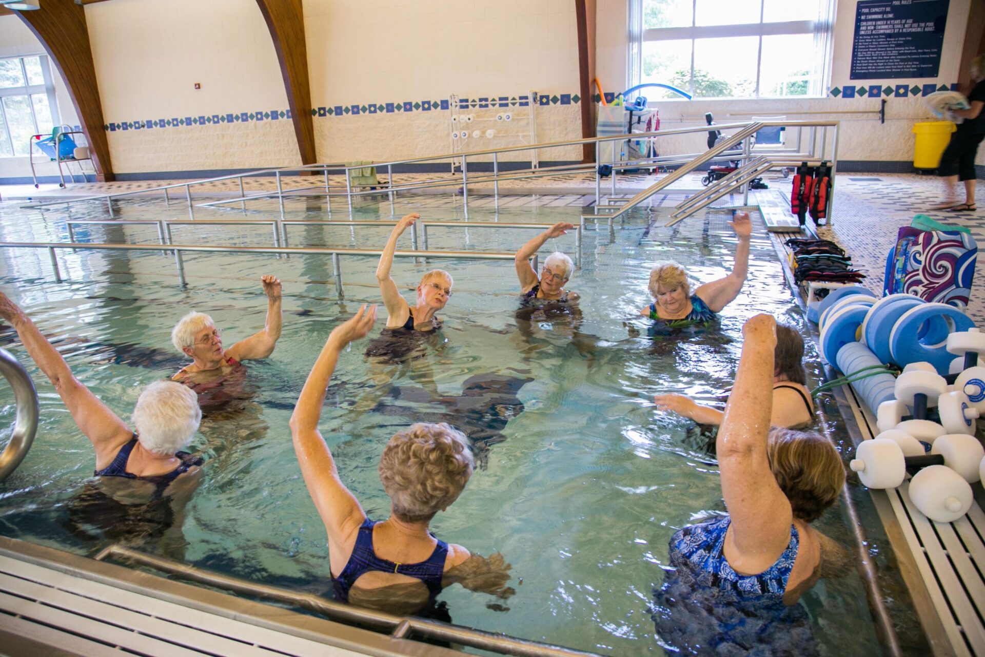 Seniors stretching together in indoor pool