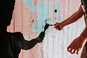 Person painting fence blue