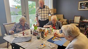 Tom Nuss and painters around a table