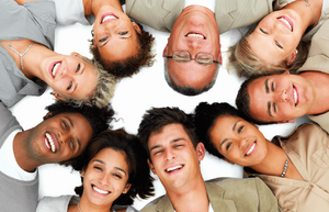 Group of people laying in a circle smiling together