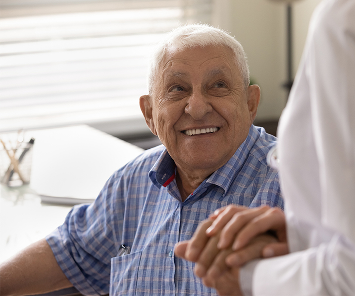 Senior man holding nurses hand