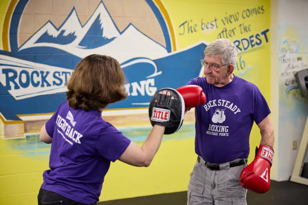Senior man boxing with instructor