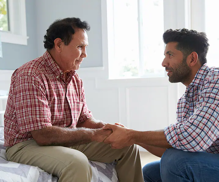 Employee holding senior mans hands