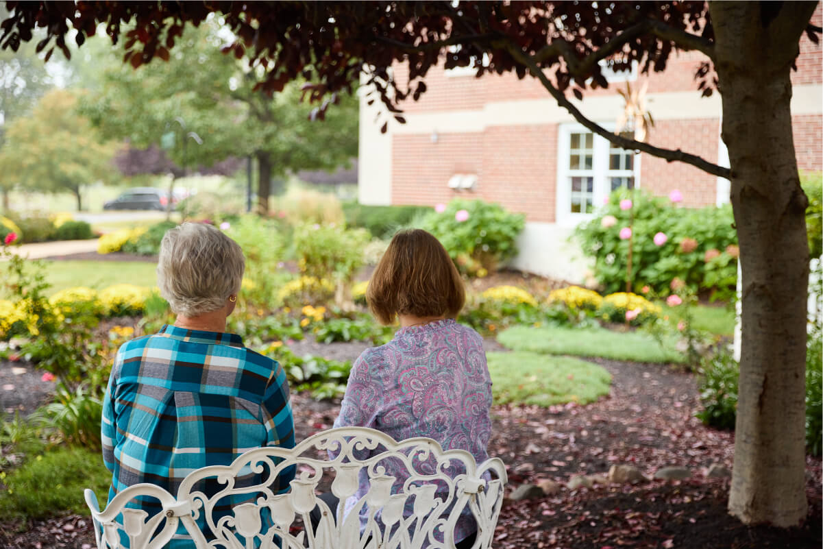 Senior women looking out at the garden from a bench