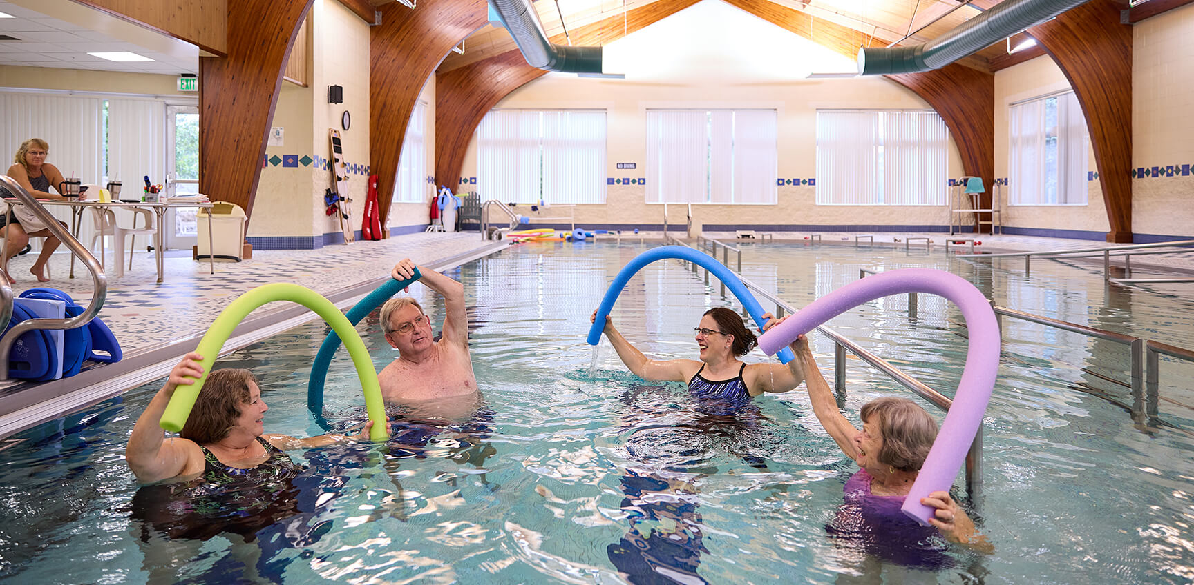 Seniors exercising with pool noodles