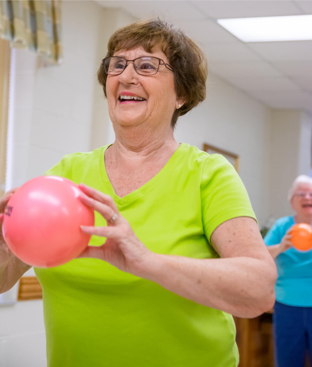 Woman holding a small exercise ball at a class