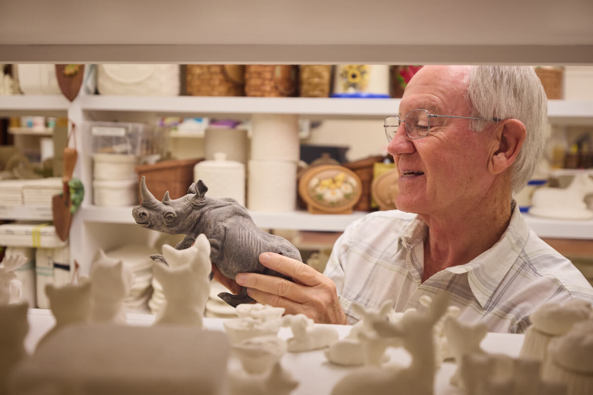 Senior man inspecting his ceramics