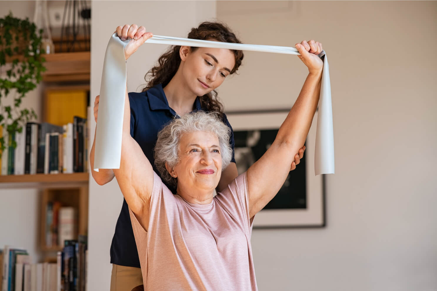 Senior woman using bands to stretch with nurse