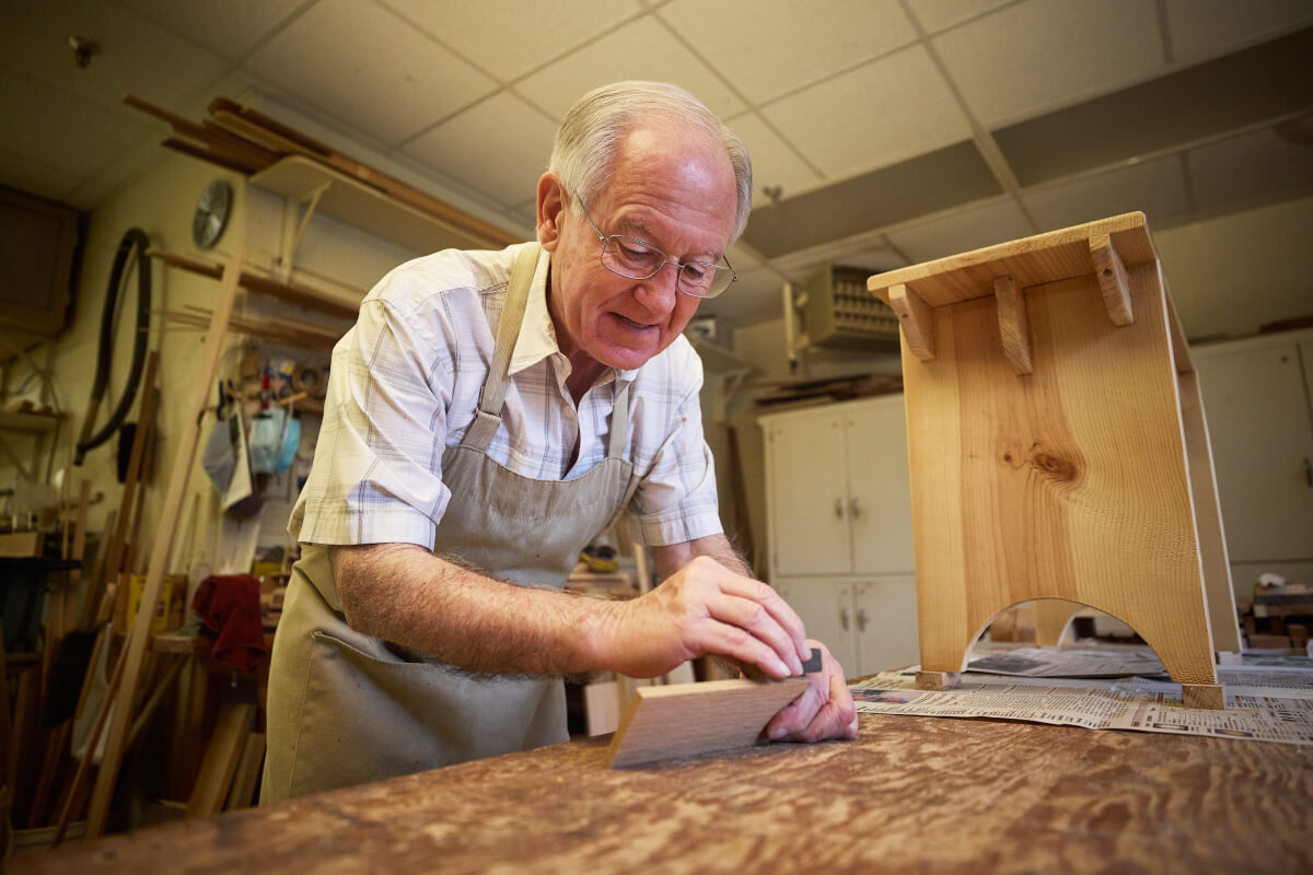 Senior man sanding wood