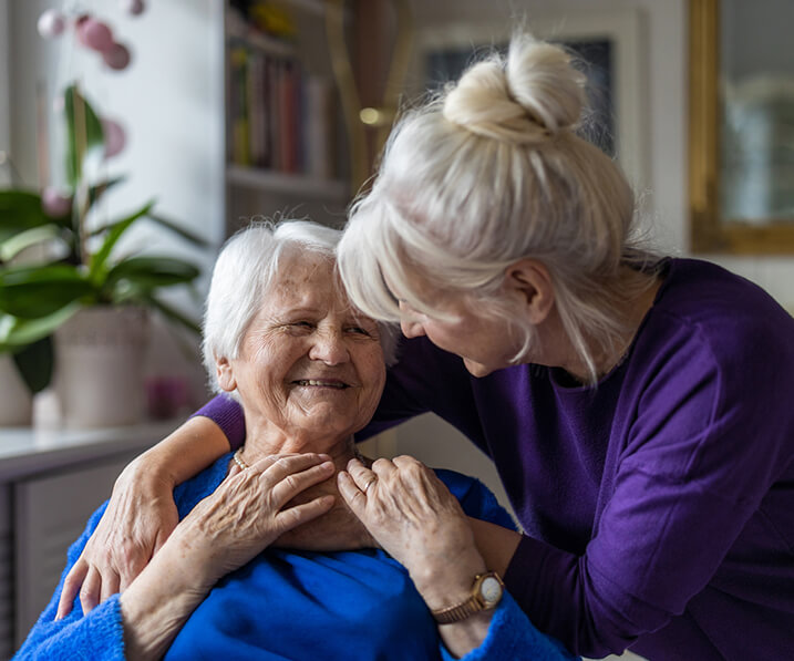 Senior embracing staff member