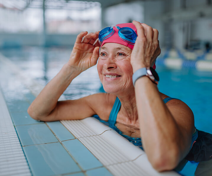 Senior woman smiling on the edge of a pool