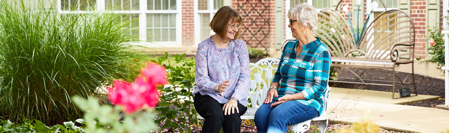 Seniors talking on garden bench