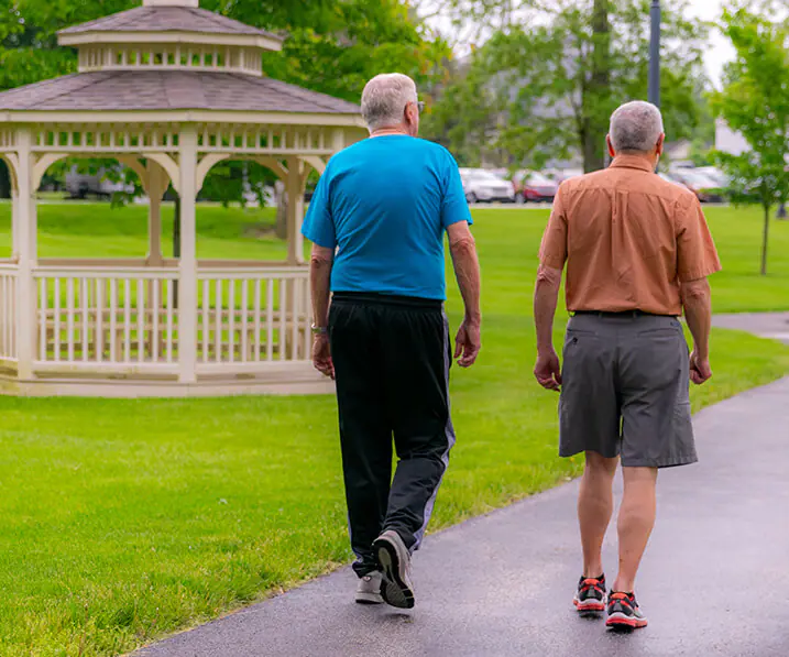 Two seniors walking by a gazebo