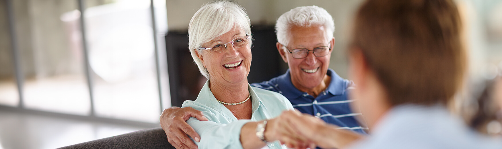 Senior couple shaking hands with employee