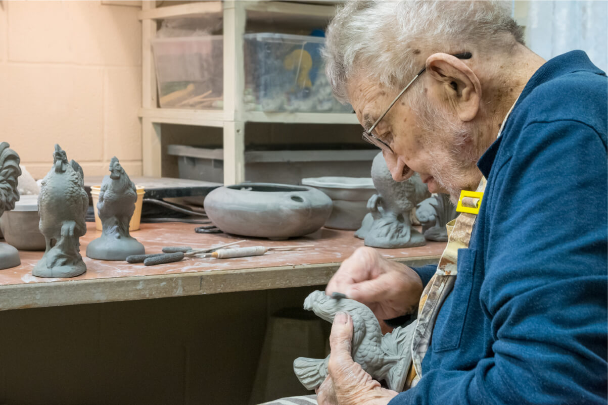 Senior man shaping his ceramics