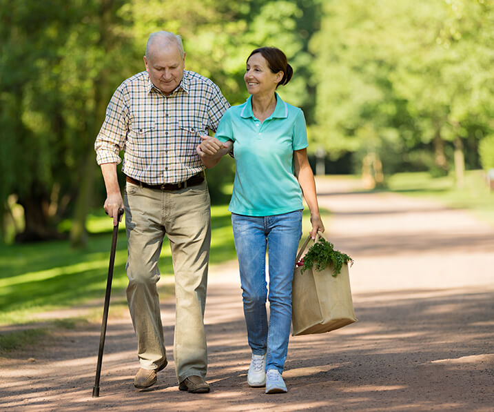 Employee assisting senior man with his bag