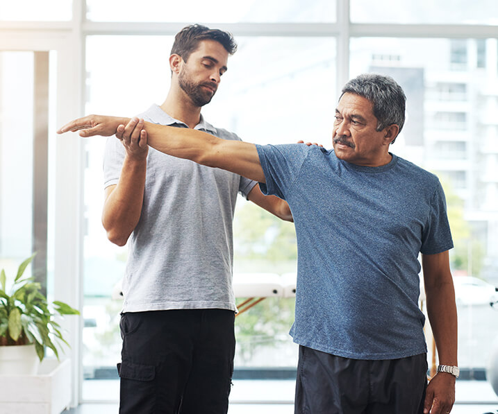 Physical therapist helping man stretch