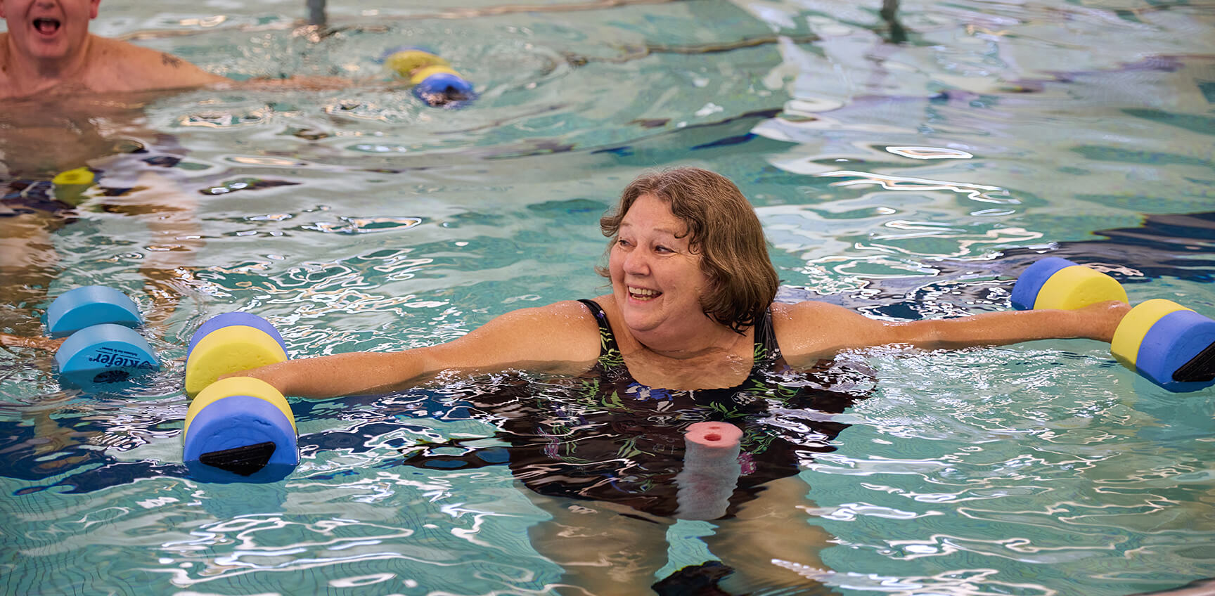 Senior woman doing aerobics in the pool