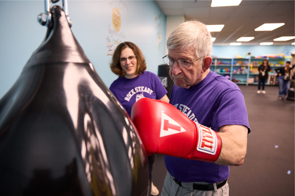 Man using the punching bag with instructor