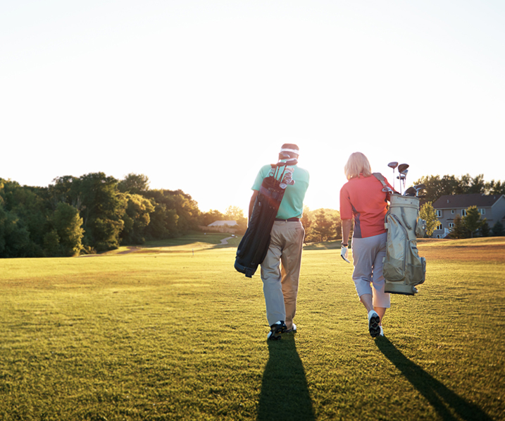 Seniors walking the golf course with their golf bags