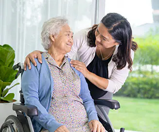 Employee checking in on senior woman in her wheelchair