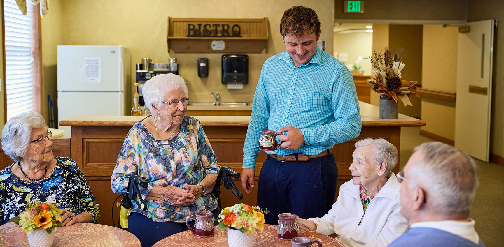 Employee talking to residents at a cafe table