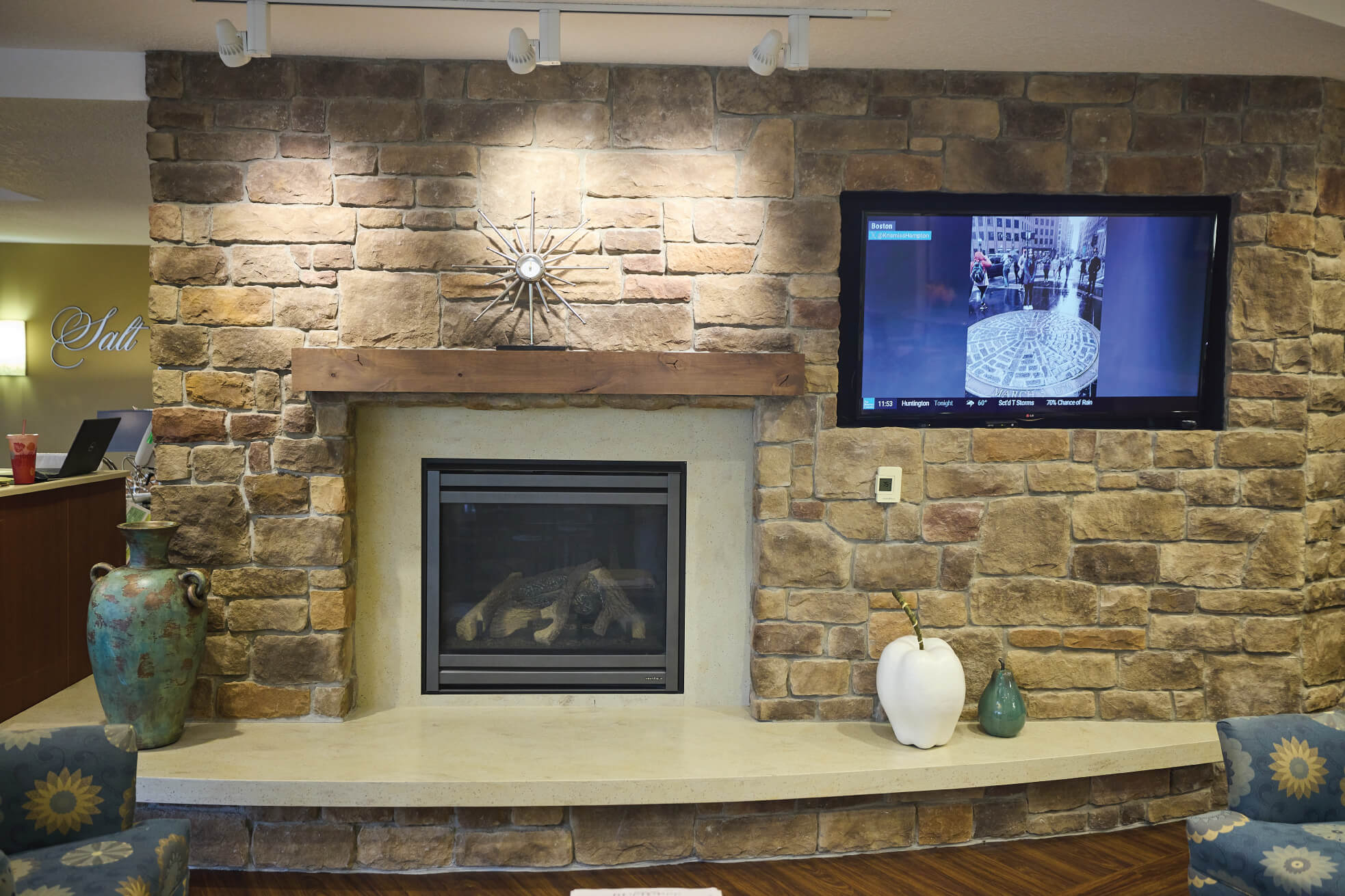 Unlit fireplace next to a TV with chairs around