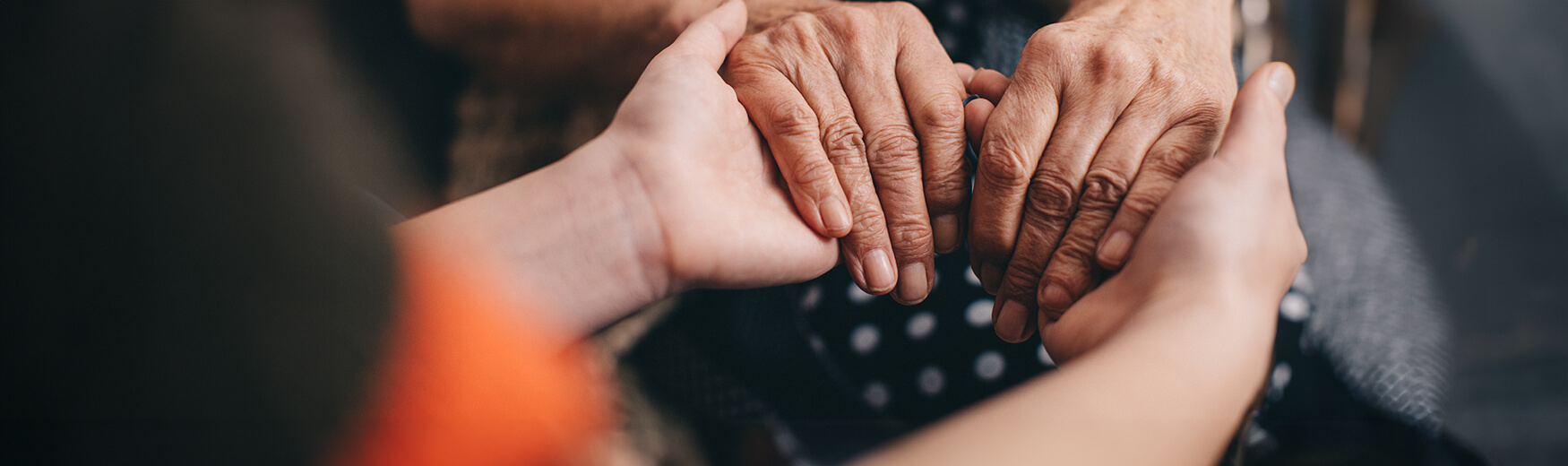 Person holding the hands of a senior person