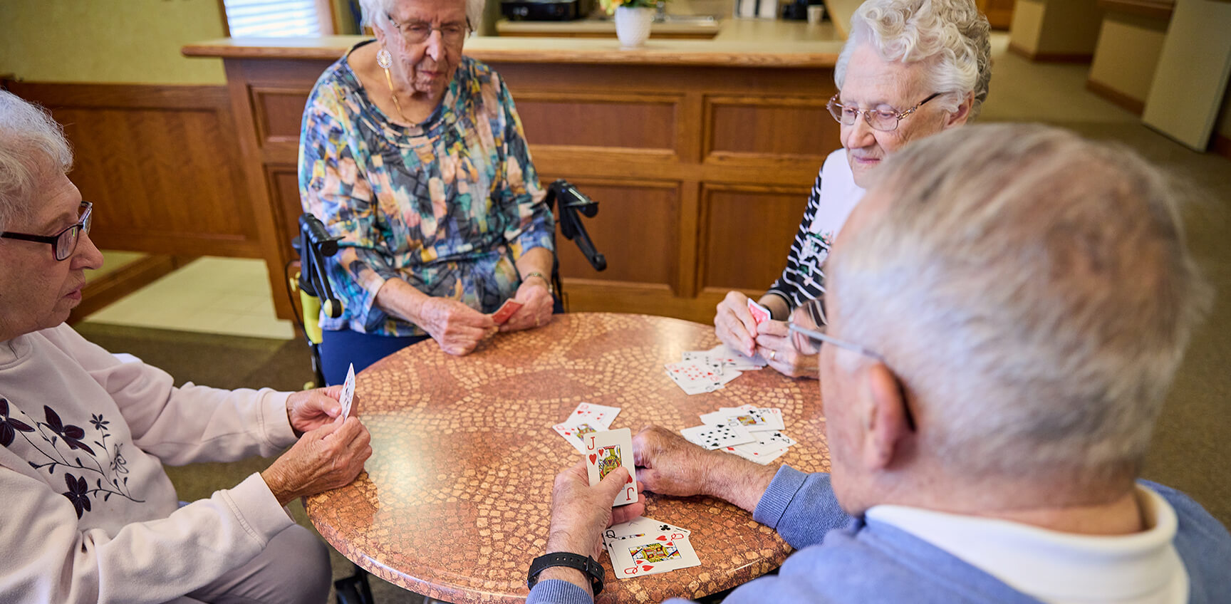 Four seniors playing cards