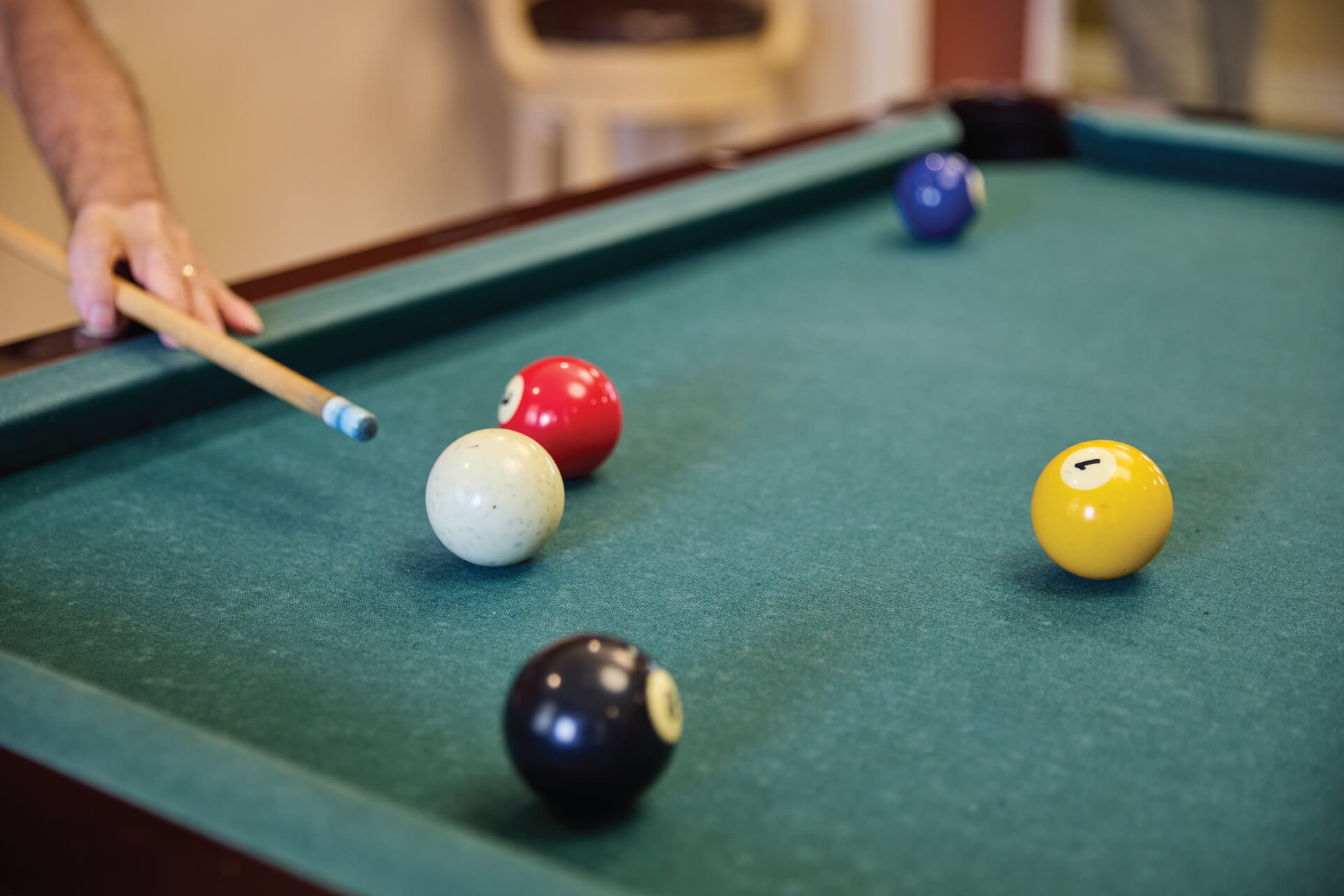 Person aiming pool cue on a pool table