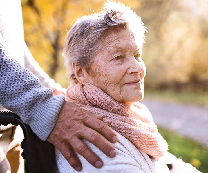 senior woman in a wheelchair being helped and comforted