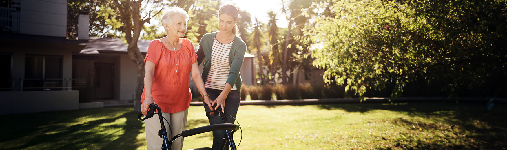 Employees assisting a senior woman with her walker outside