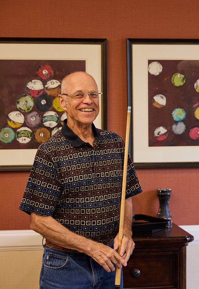 senior man holding a pool stick