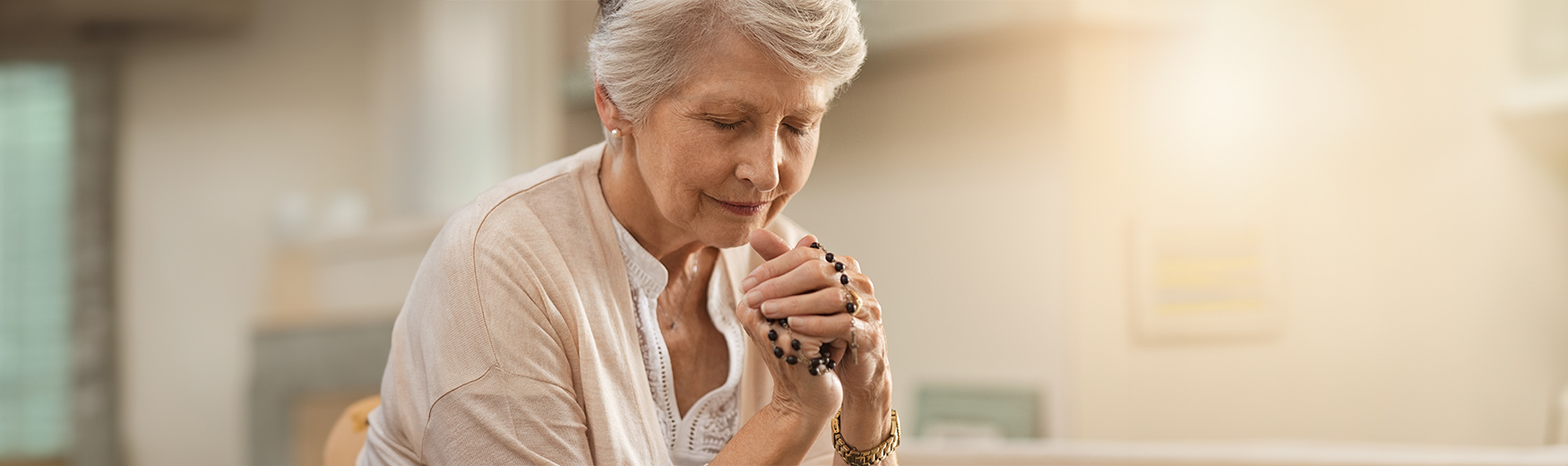 woman praying with rosary beads