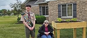 Jacob DeWitt and his grandmother with handmade raised garden bed