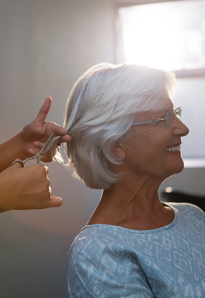 Happy senior woman getting a haircut