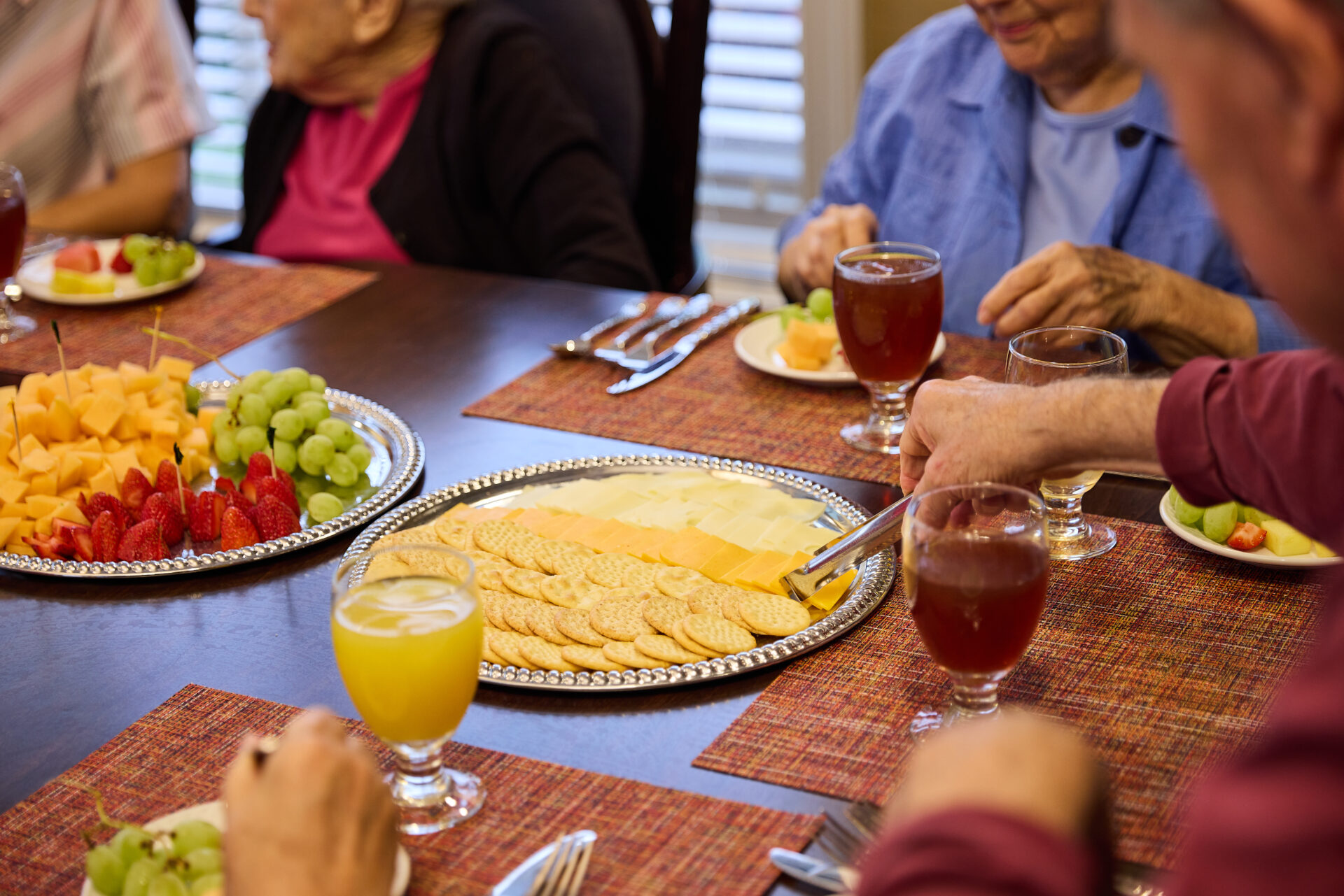 Seniors around a table for light lunch and a charcuterie board.