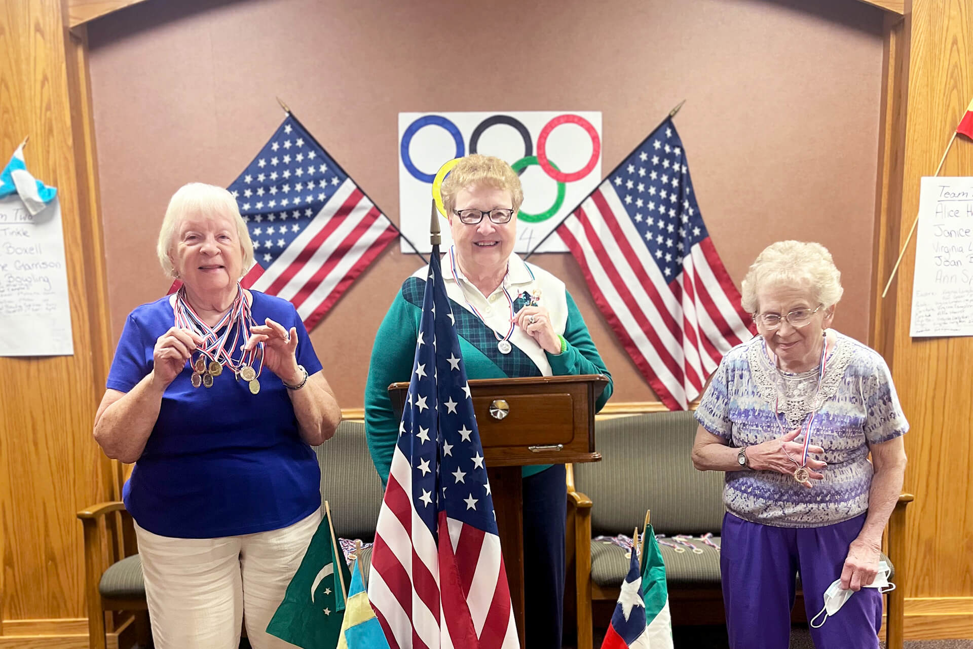 Three senior women on the Senior Living Olympics podium.