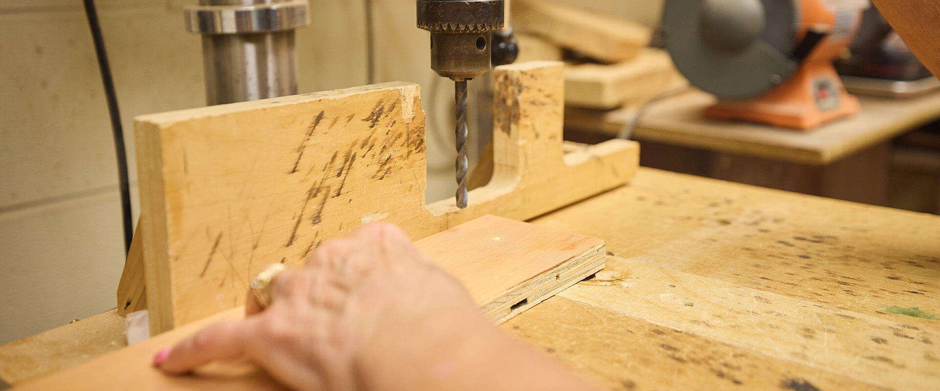 Senior using drill in workshop