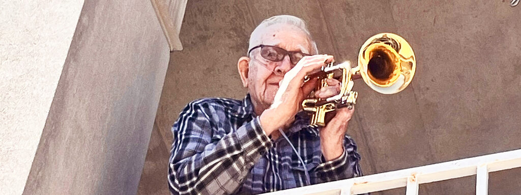 Senior man playing trumpet outside