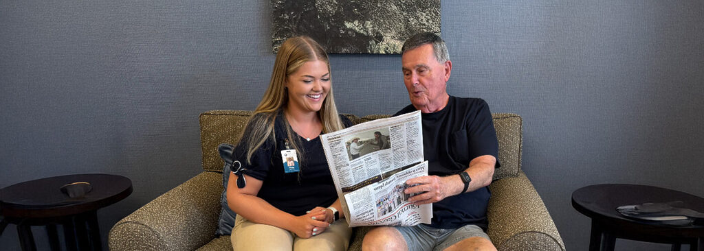 Resident reads newspaper with concierge