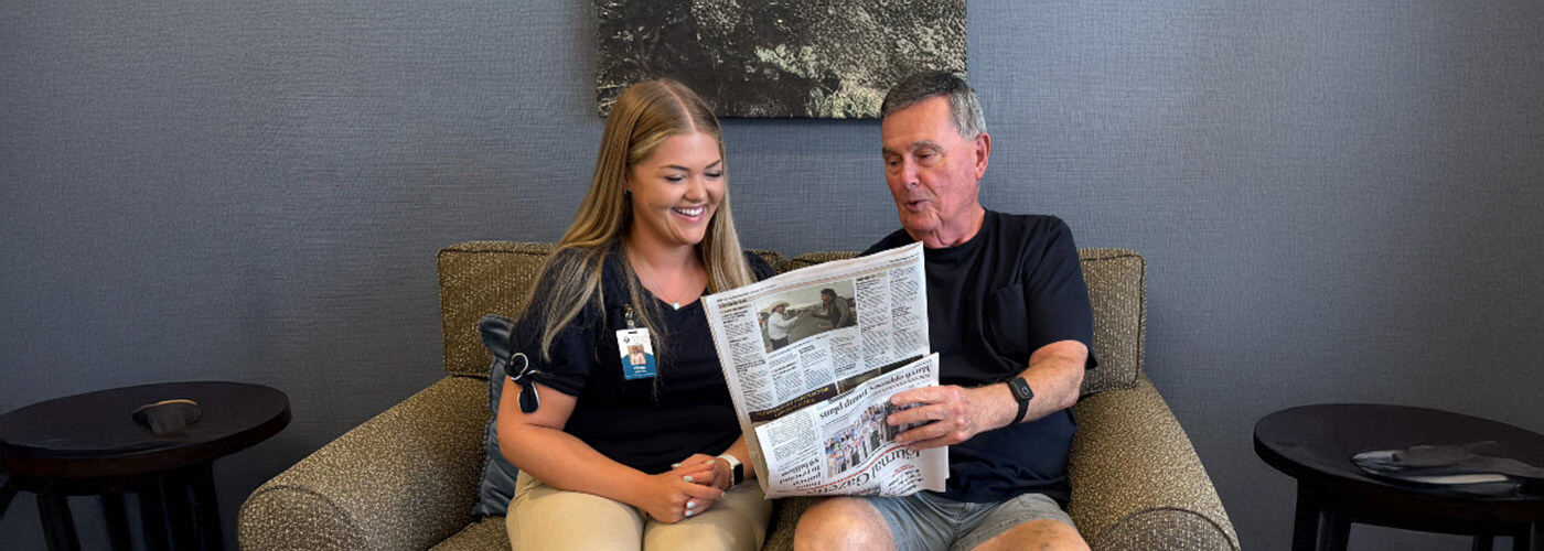 Resident reads newspaper with concierge