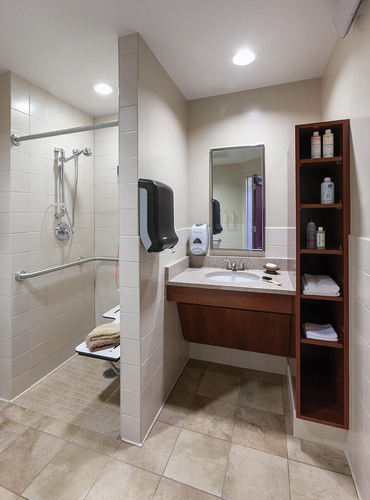 Accessible bathroom with shower seat and safety rails in a senior living unit.