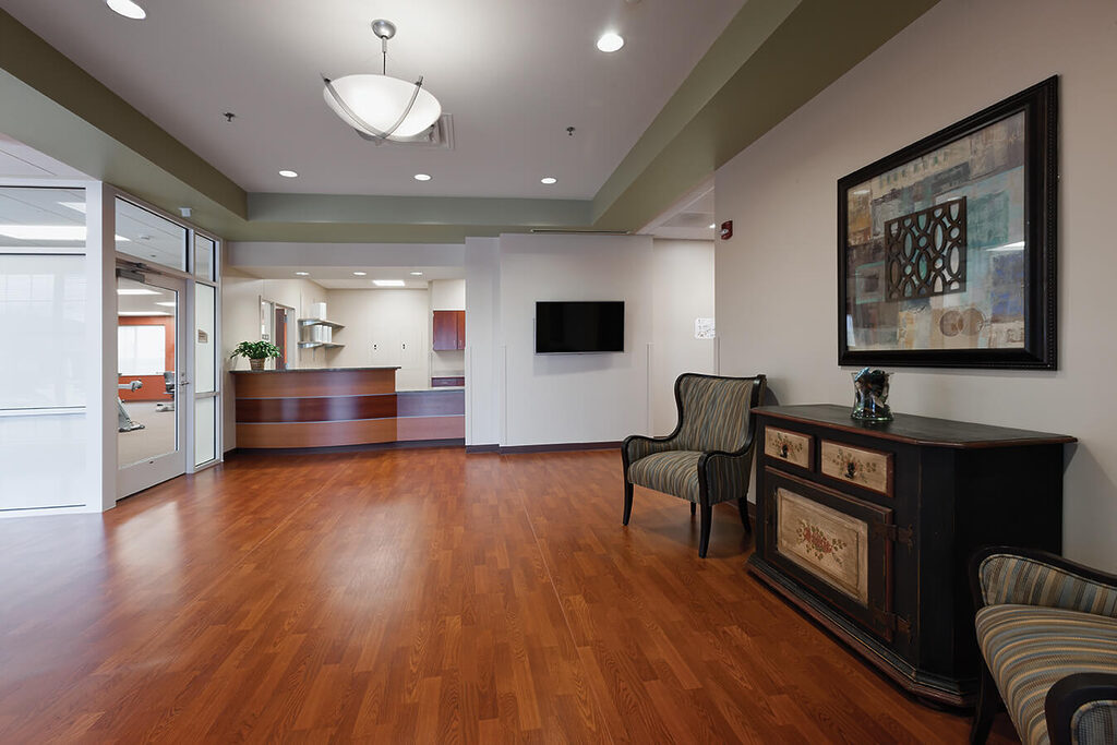 Elegant lobby with wood floors, seating, and a modern reception desk.