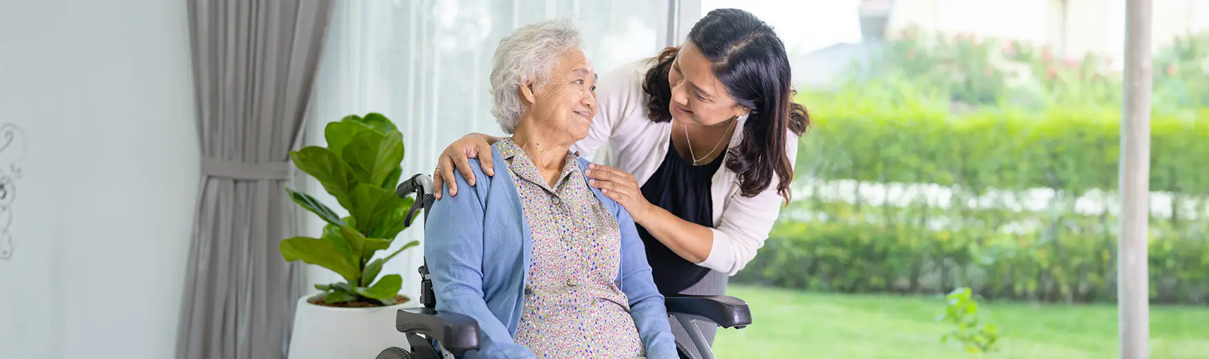 Senior woman in wheelchair and caregiver
