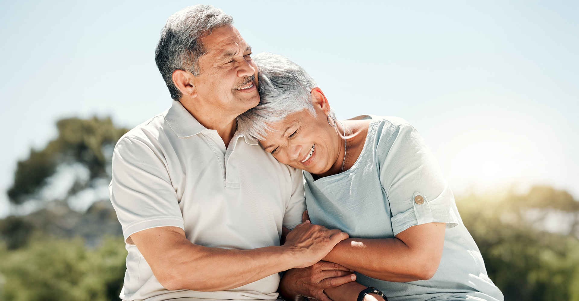 Senior man and woman embrace outdoors