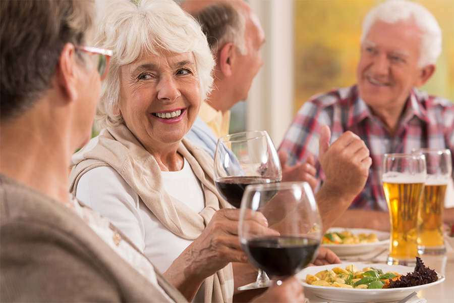Senior woman smiles with a glass of wine