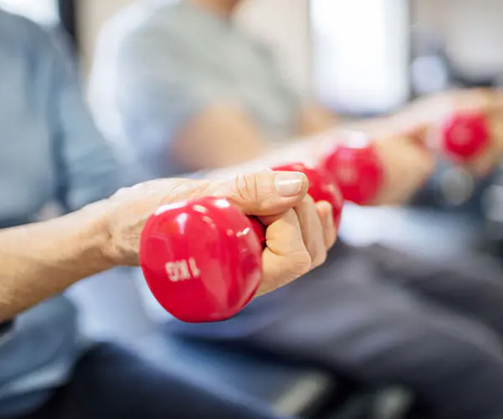 Seniors use hand weights during rehabilitation