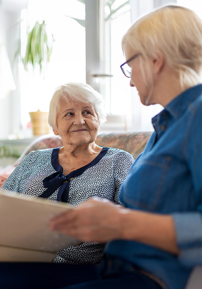 Caregiver goes through photo album with elderly woman